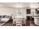Open concept dining area with elegant chandelier and hardwood floors connects to a cozy living space at 690 W 172Nd Pl, Broomfield, CO 80023
