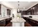 Spacious kitchen featuring a large island, dark wood cabinets, granite countertops and stainless steel appliances at 690 W 172Nd Pl, Broomfield, CO 80023