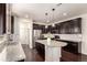 Spacious kitchen with dark wood cabinets, granite countertops, stainless steel appliances, and an island at 690 W 172Nd Pl, Broomfield, CO 80023