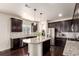 Gourmet kitchen featuring stainless steel appliances, granite countertops, and stylish dark wood cabinetry at 690 W 172Nd Pl, Broomfield, CO 80023