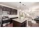 Spacious kitchen featuring an island, stainless steel appliances, granite countertops, and a view to the living area at 690 W 172Nd Pl, Broomfield, CO 80023