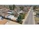 Aerial view of the property with mature trees, detached garages, and proximity to the street at 1299 S Dale Ct, Denver, CO 80219
