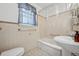 Bright bathroom featuring a pedestal sink, tiled walls, and a shower at 1299 S Dale Ct, Denver, CO 80219