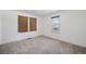Bedroom with neutral carpet, white walls, and two windows providing natural light and street view at 1299 S Dale Ct, Denver, CO 80219