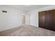 Bright bedroom featuring neutral carpet, white walls, and a closet at 1299 S Dale Ct, Denver, CO 80219