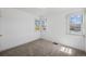 Bright bedroom featuring neutral carpet, fresh white walls, and natural light from two windows at 1299 S Dale Ct, Denver, CO 80219