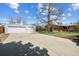 View of the property's detached two-car garage and long driveway on a sunny day at 1299 S Dale Ct, Denver, CO 80219