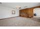 Spacious living room with carpet, wood built-ins, and ample light from a large window at 1299 S Dale Ct, Denver, CO 80219