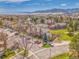 Picturesque aerial view of a residential neighborhood nestled amidst lush greenery and mountains under a clear blue sky at 9658 W Chatfield Ave # D, Littleton, CO 80128