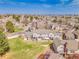 Expansive aerial view of a residential neighborhood with well-spaced homes, mature trees, and green spaces under sunny skies at 9658 W Chatfield Ave # D, Littleton, CO 80128