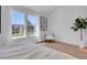 Sunlit bedroom with modern chair and hardwood floors at 9658 W Chatfield Ave # D, Littleton, CO 80128