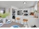 Modern kitchen with white cabinetry, a breakfast bar and stainless steel appliances plus laundry area at 9658 W Chatfield Ave # D, Littleton, CO 80128