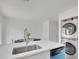 Clean kitchen with quartz countertops, stainless steel sink, in-unit laundry and dining area at 9658 W Chatfield Ave # D, Littleton, CO 80128