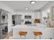 Bright and modern kitchen with stainless steel appliances, white cabinetry, breakfast bar, and adjacent laundry at 9658 W Chatfield Ave # D, Littleton, CO 80128