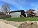 This home boasts a big side yard, landscaping, and gray and red paint scheme at 12452 W Dumbarton Pl, Morrison, CO 80465