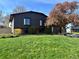 Charming home featuring well-maintained lawn, mature trees, and unique dark gray and red exterior paint scheme at 12452 W Dumbarton Pl, Morrison, CO 80465