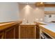 Cozy basement wet bar with wooden cabinets, butcher block countertop, and ample storage space at 9025 Jellison Ct, Broomfield, CO 80021