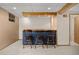 Basement wet bar with wooden bar stools, a butcher block countertop, and neutral carpeting at 9025 Jellison Ct, Broomfield, CO 80021