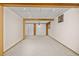 Unfinished basement with neutral carpet, exposed beams, and a storage closet with sliding doors at 9025 Jellison Ct, Broomfield, CO 80021