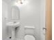 Bright bathroom with a pedestal sink, white toilet, and a Hollywood style vanity light at 9025 Jellison Ct, Broomfield, CO 80021