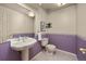Half bathroom with toilet, pedestal sink, and purple floral wallpaper at 9025 Jellison Ct, Broomfield, CO 80021