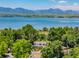 Scenic view of home near a lake and mountains, surrounded by lush trees at 9025 Jellison Ct, Broomfield, CO 80021