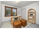 Inviting home office with natural light, a wooden desk, woven ottomans and a wicker bookshelf at 9025 Jellison Ct, Broomfield, CO 80021
