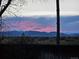 Scenic landscape view with vibrant pink and blue sunset over the mountains, captured from the backyard fence at 9025 Jellison Ct, Broomfield, CO 80021