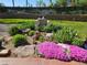 Beautifully landscaped backyard featuring colorful flowers, rock accents, and charming garden statues at 9025 Jellison Ct, Broomfield, CO 80021