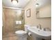 Bathroom featuring tiled shower with glass door, white toilet, and pedestal sink at 1020 15Th St # 20N, Denver, CO 80202