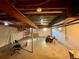Unfinished basement featuring exposed ceiling beams, concrete floor, and small windows for natural light at 7245 S Dexter St, Centennial, CO 80122