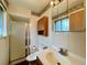 Bathroom featuring a single sink vanity, toilet, shower with sliding doors, medicine cabinet, and tile walls at 7245 S Dexter St, Centennial, CO 80122