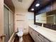 A full bathroom featuring tile flooring, a bathtub with shower, toilet, and vanity sink with large mirror at 7245 S Dexter St, Centennial, CO 80122