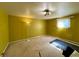 Bedroom space featuring bright yellow walls, carpeted floors, natural light from a window, and overhead lighting at 7245 S Dexter St, Centennial, CO 80122