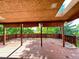 Covered outdoor deck area with wooden flooring, wood railing, and an adjacent view of the treeline at 7245 S Dexter St, Centennial, CO 80122