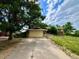 Home exterior featuring a large driveway, mature trees, and a two-car garage, showcasing the property's curb appeal at 7245 S Dexter St, Centennial, CO 80122