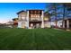 Well-manicured backyard with fire pit, modern exterior, stone accents, and a balcony for outdoor relaxation at 5787 Powell Rd, Parker, CO 80134