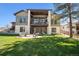 Expansive backyard featuring a fire pit, lush green lawn, and a modern home exterior with a balcony at 5787 Powell Rd, Parker, CO 80134