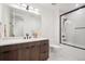 Modern bathroom with a dark wood vanity, quartz countertop, and glass-enclosed shower with black trim at 5787 Powell Rd, Parker, CO 80134