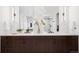 Double vanity bathroom featuring marble countertops, modern fixtures, and custom cabinets at 5787 Powell Rd, Parker, CO 80134