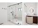 Modern bathroom featuring a frameless glass shower, marble tile, and a vanity with a lighted makeup mirror at 5787 Powell Rd, Parker, CO 80134