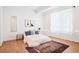 Bright bedroom with light hardwood floors, area rug, and lots of natural light at 5787 Powell Rd, Parker, CO 80134