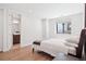 Bright bedroom with hardwood floors, a bed with white linens, and a window providing natural light at 5787 Powell Rd, Parker, CO 80134