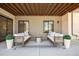 Cozy covered patio with symmetrical seating arrangements, neutral tones, and a view of the well-lit interior at 5787 Powell Rd, Parker, CO 80134