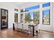 Open dining area filled with natural light from large windows overlooking the wooded backyard at 5787 Powell Rd, Parker, CO 80134