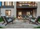 Inviting outdoor fire pit area with comfortable seating, stone pavers, and views of the home's modern exterior at 5787 Powell Rd, Parker, CO 80134