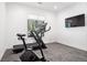 Bright home gym with a treadmill, exercise bike, large window and television at 5787 Powell Rd, Parker, CO 80134