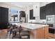 Modern kitchen with a large center island, dark cabinets, and stainless steel appliances at 5787 Powell Rd, Parker, CO 80134