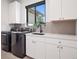 Well-organized laundry room with modern appliances, white cabinetry, a sink, and ample countertop space at 5787 Powell Rd, Parker, CO 80134