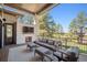 Covered outdoor patio featuring a stone fireplace, TV, and cozy seating area at 5787 Powell Rd, Parker, CO 80134